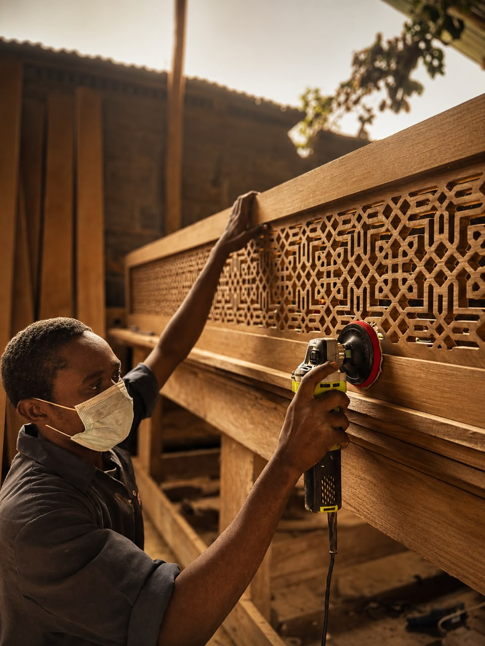 Zagalo craftsman sanding a carved timber screen panel